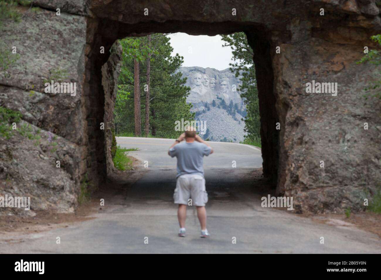 KEYSTONE, SOUTH DAKOTA - June 27, 2014: A tourist takes pictures through the Scovel Johnson tunnel on Iron Mountain Road with views of Mount Rushmore Stock Photo