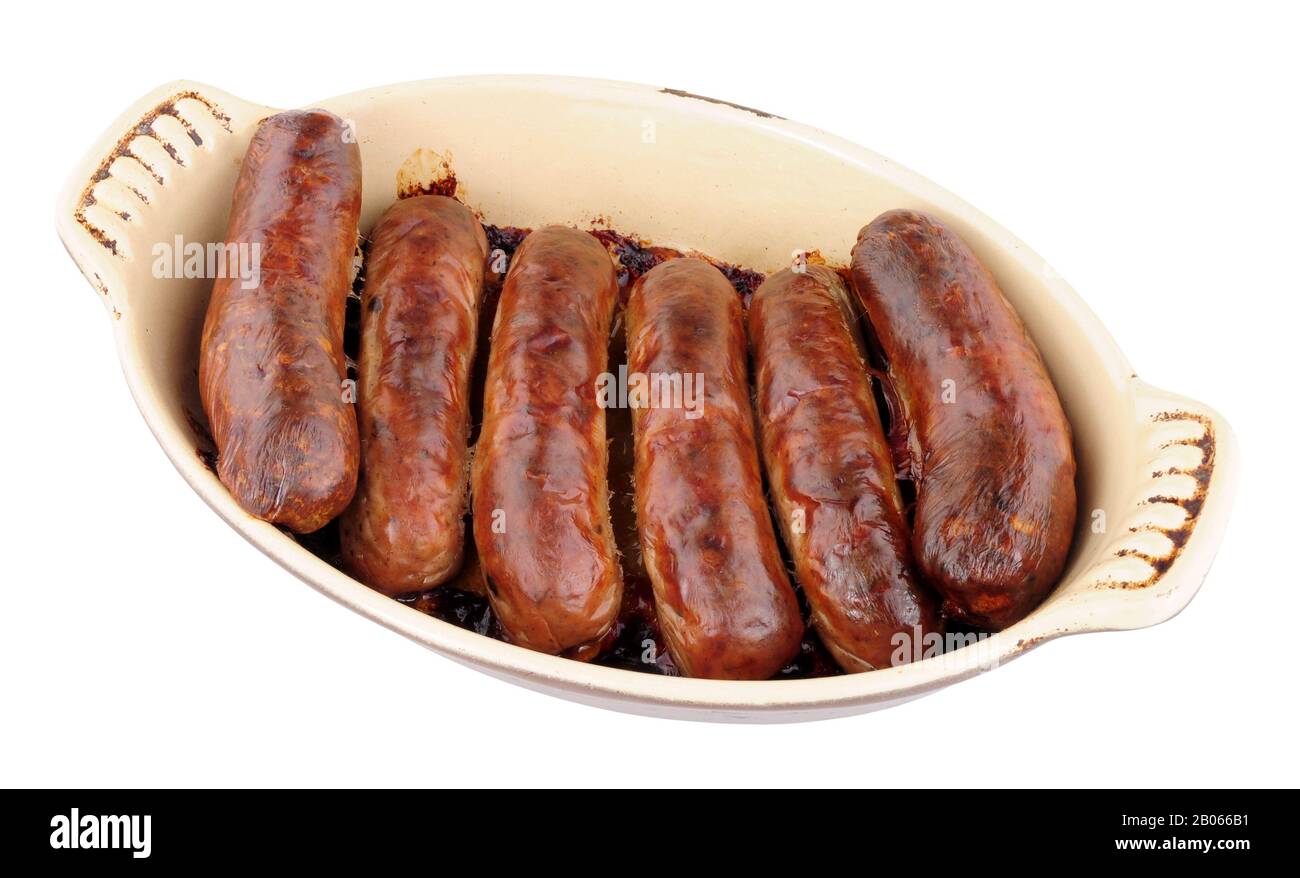 Baked pork sausages in an oven dish isolated on a white background
