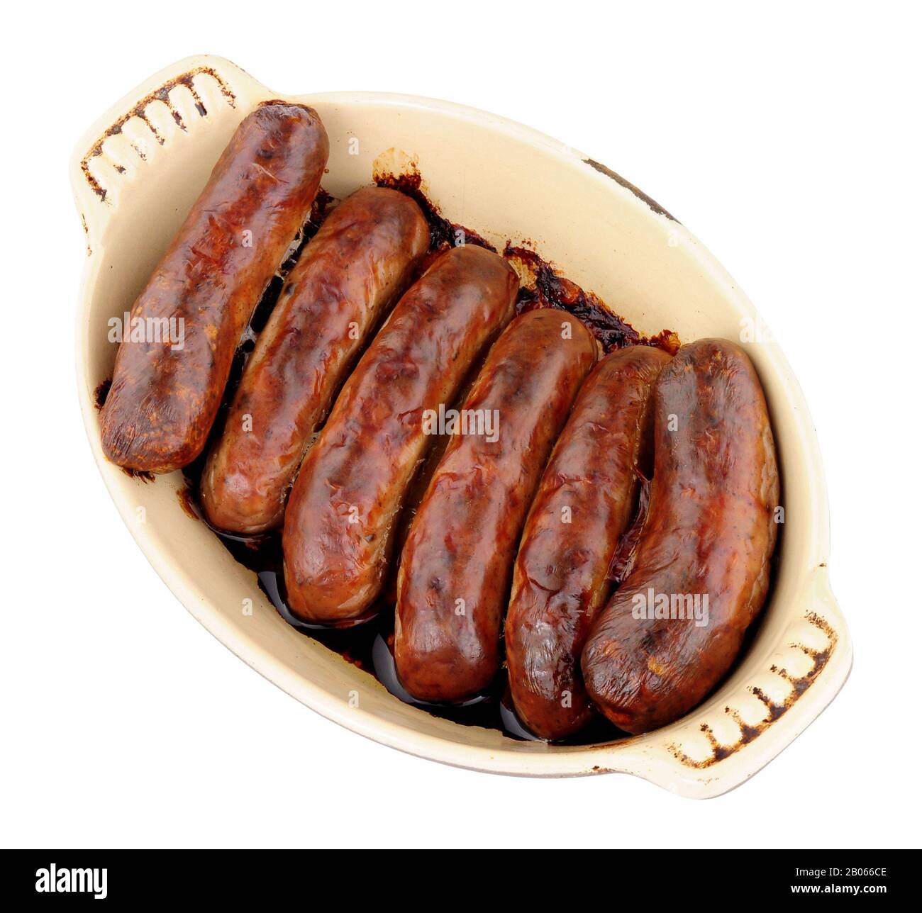 Baked pork sausages in an oven dish isolated on a white background