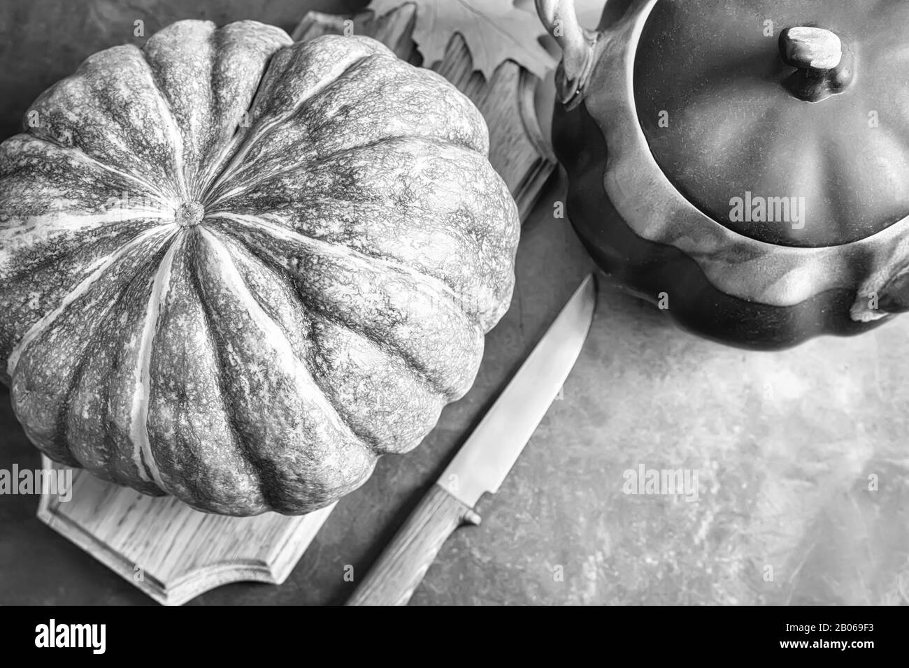A large pumpkin next to a ceramic pot Stock Photo