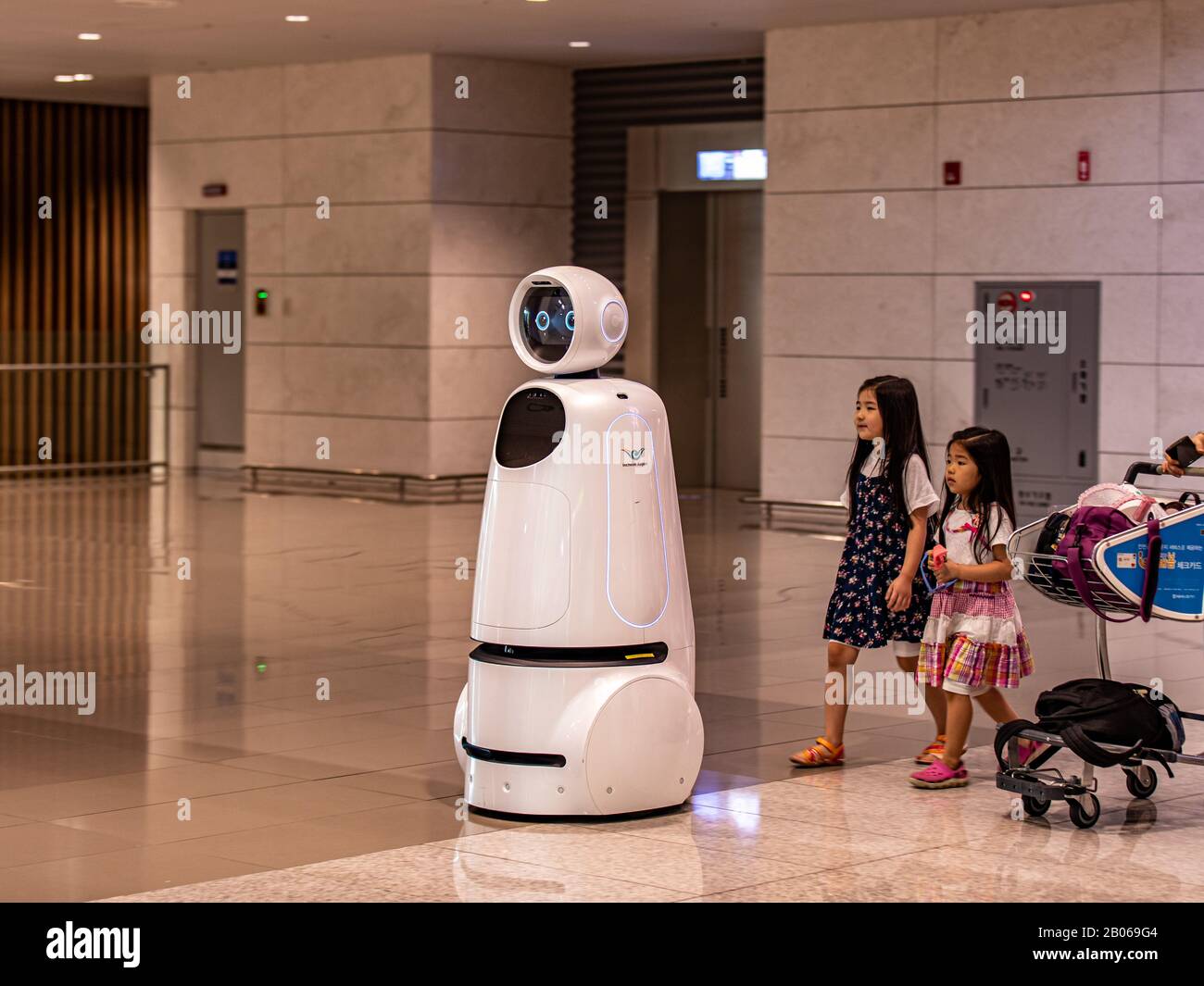 Incheon  South Korea - 14 September 2019: Two little girl follow AIRSTAR - a passenger aiding robot at Incheon International Airport Stock Photo
