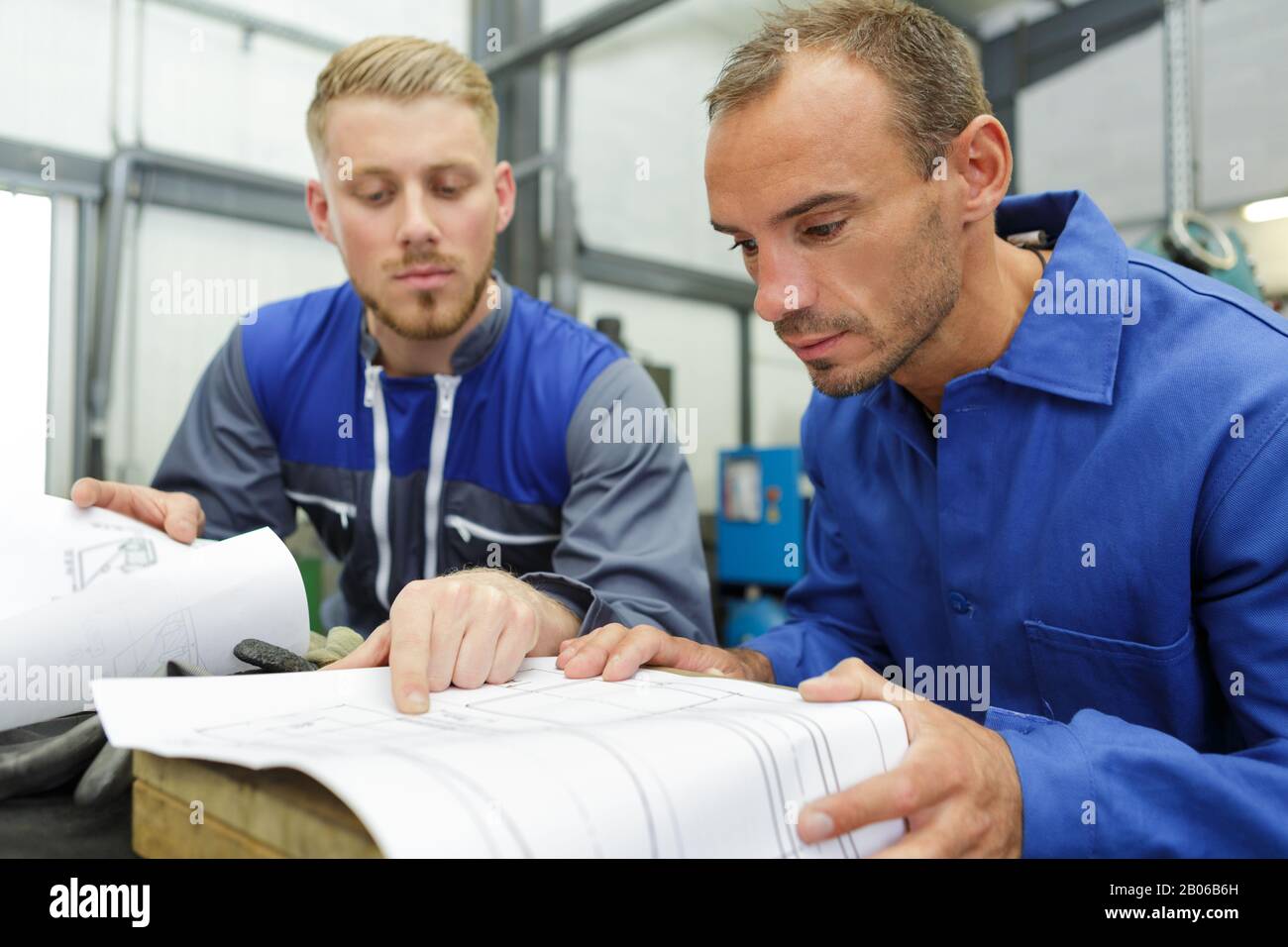 two technicians read a plan in the workshop Stock Photo