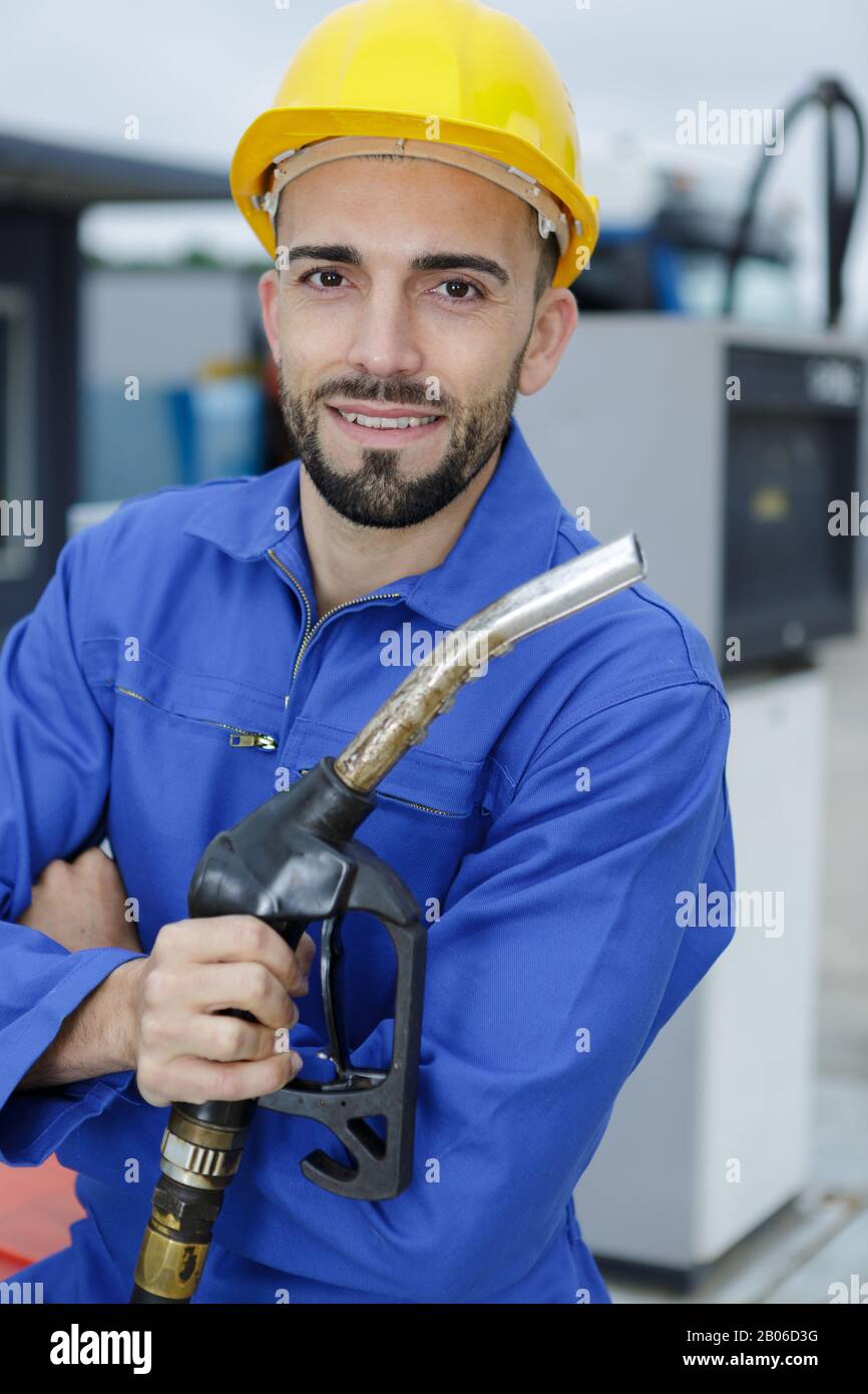 facility worker holding gas pump Stock Photo Alamy