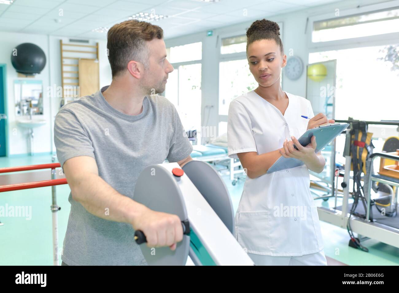 nurse assisting mature man to walk using walker Stock Photo - Alamy
