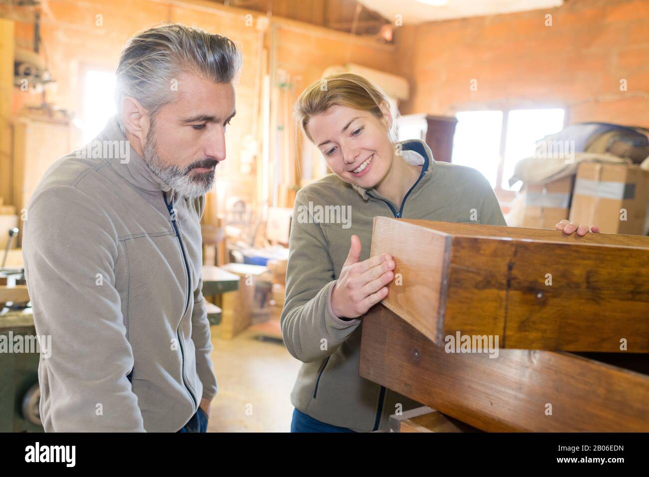workers looking at wood furniture Stock Photo Alamy
