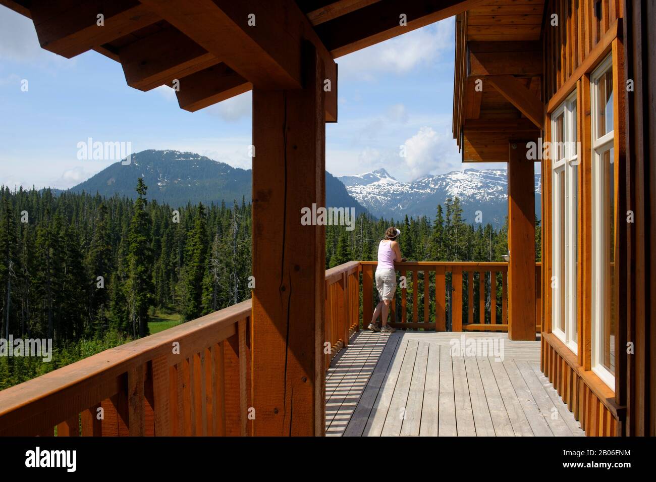 CANADA, BRITISH COLUMBIA, VANCOUVER ISLAND, STRATHCONA PROVINCIAL PARK, RAVEN LODGE WITH WOMAN ON DECK (MODEL RELEASED) Stock Photo