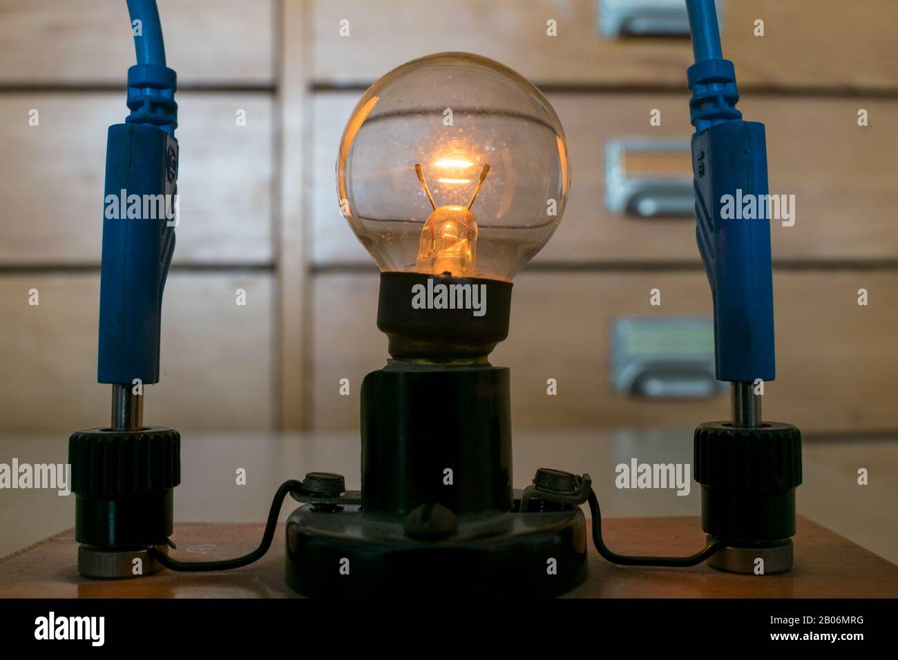 Glowing traditional Tungsten light bulb in physics class Stock Photo