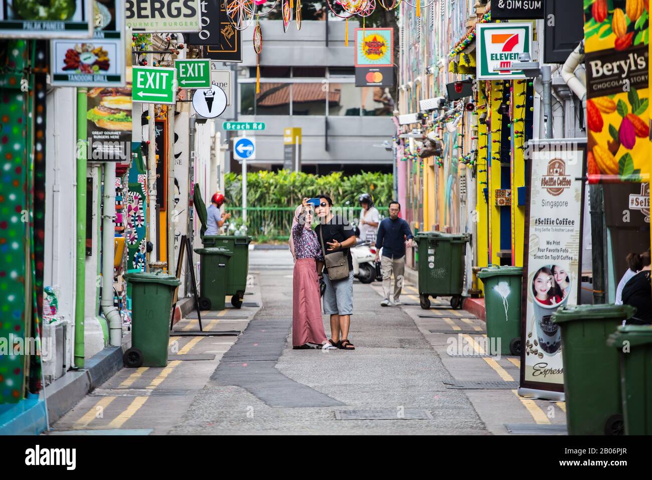 Cool indonesian couple tourists is posing for a selfie picture on the street scenes at Haji Lane, a popular place for tourism to visit in Singapore. Stock Photo