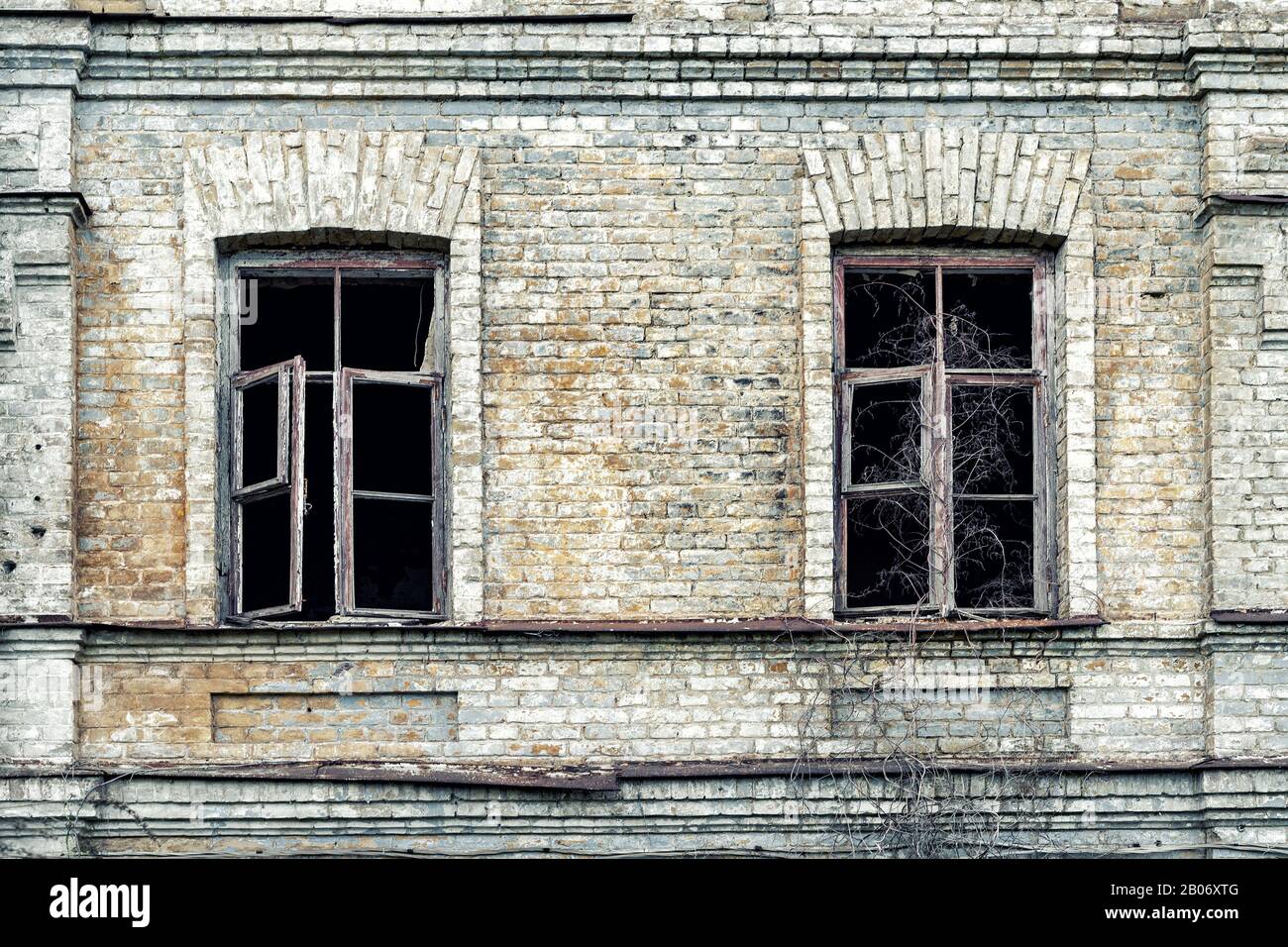 Old shabby ruined abandoned brick building wall facade with two wooden ...