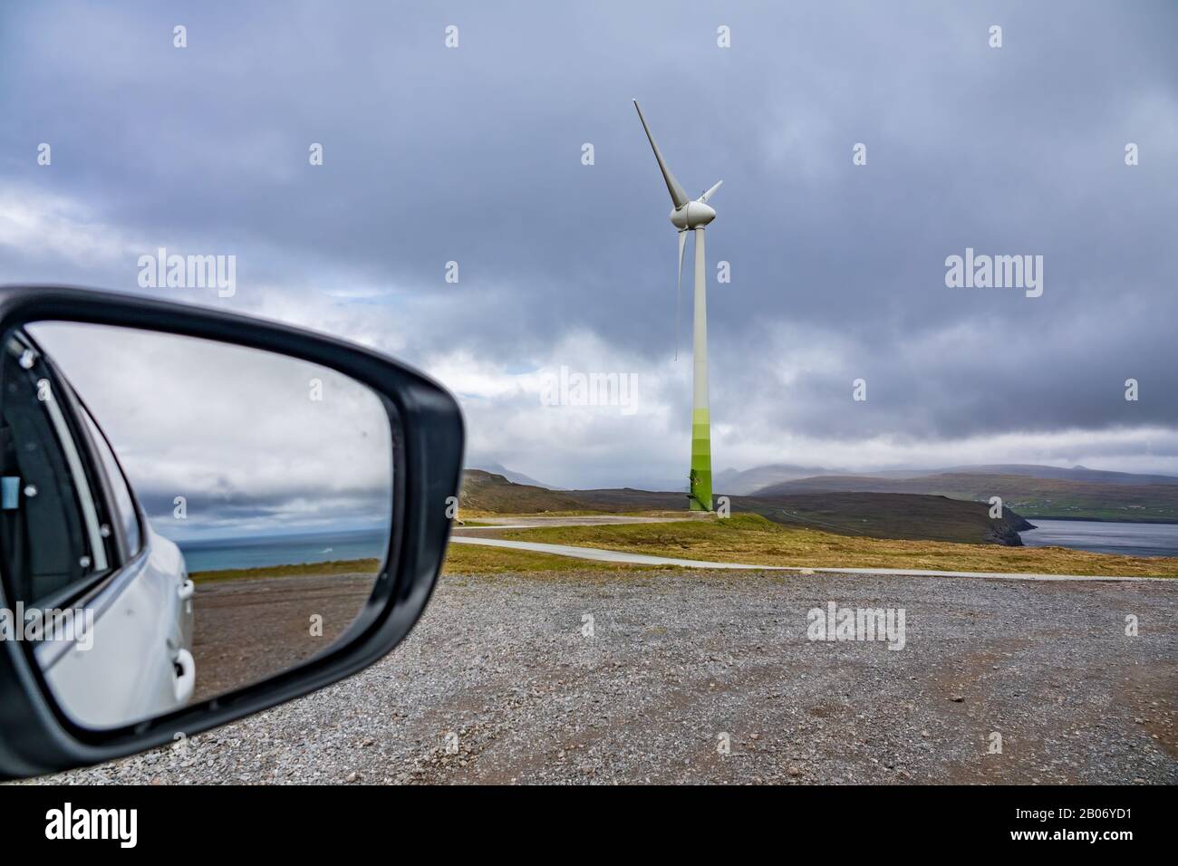 Car mirror with ocean and windmill under cloudy sky Stock Photo