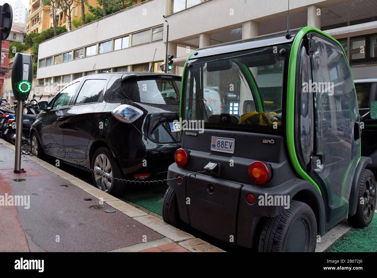 An Estrima Biro micro electric vehicle on charge at a street charging point next to a Renault Zoe EV in Monte Carlo, Monaco. 17th January 2020 Stock Photo