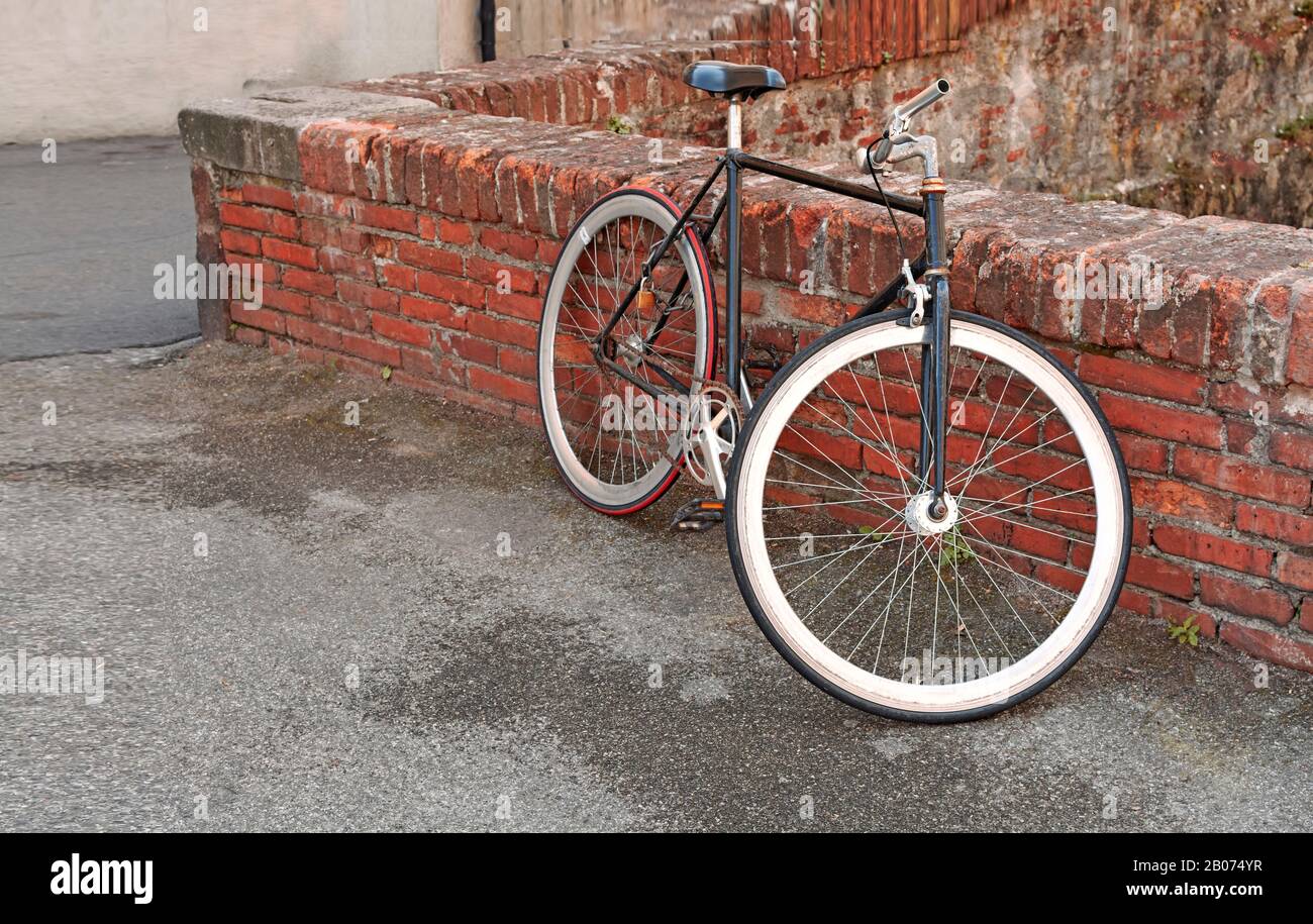 Vintage bike with white tires leaning against the brick wall Stock Photo -  Alamy