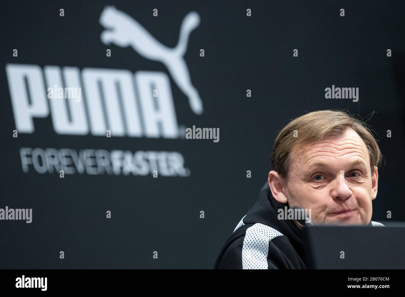 19 February 2020, Bavaria, Herzogenaurach: Björn Gulden, Chairman and Managing Director of the sporting goods manufacturer Puma SE, sits in front of the company logo before the start of the company's annual press conference. Photo: Daniel Karmann/dpa Stock Photo