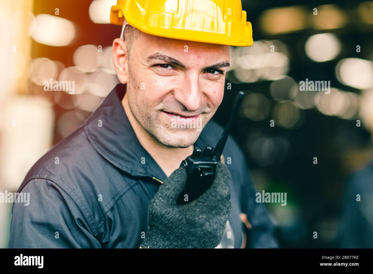 Portrait of labor worker engineer hand holding radio for talking communication with coworker in industrial factory and waring safty suit. Stock Photo