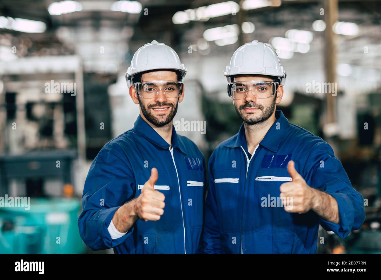 Happy worker team smiling hand show thumb up for good working in factory. Stock Photo