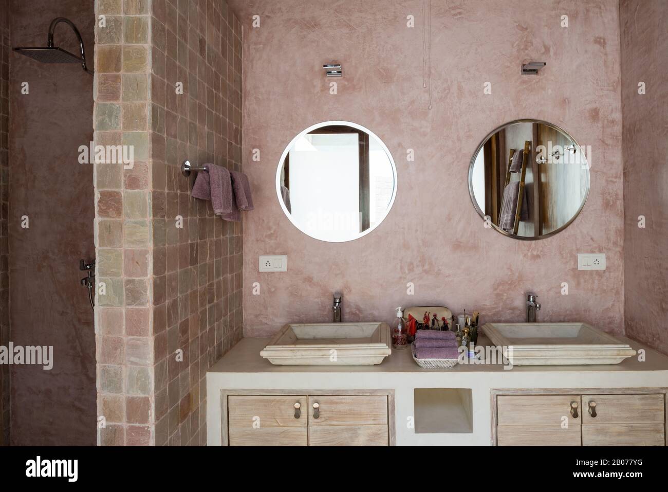 Pink toned bathroom with circular mirrors Stock Photo