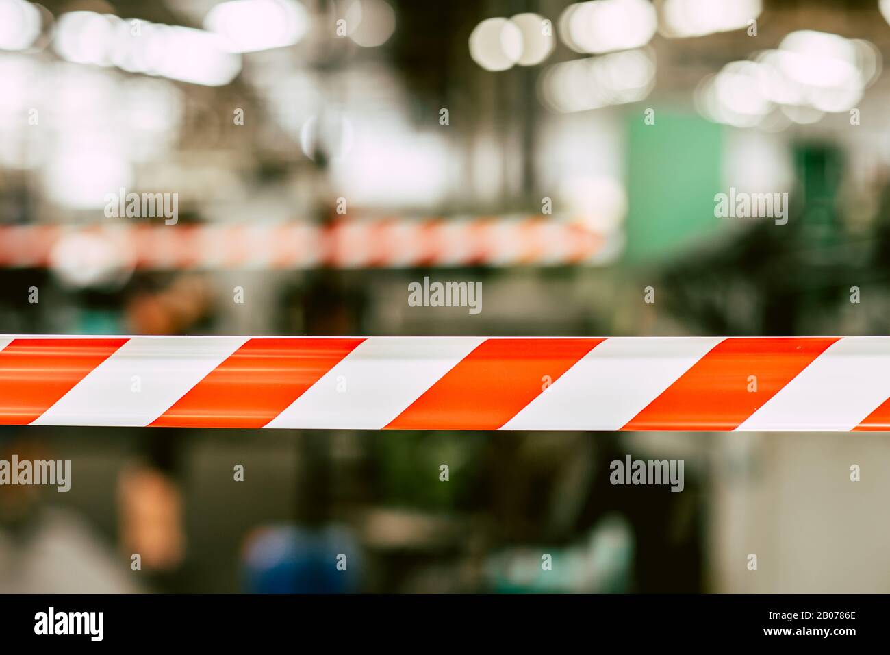 danger unsafety area caution do not enter red stripe tape with industry factory background. Stock Photo