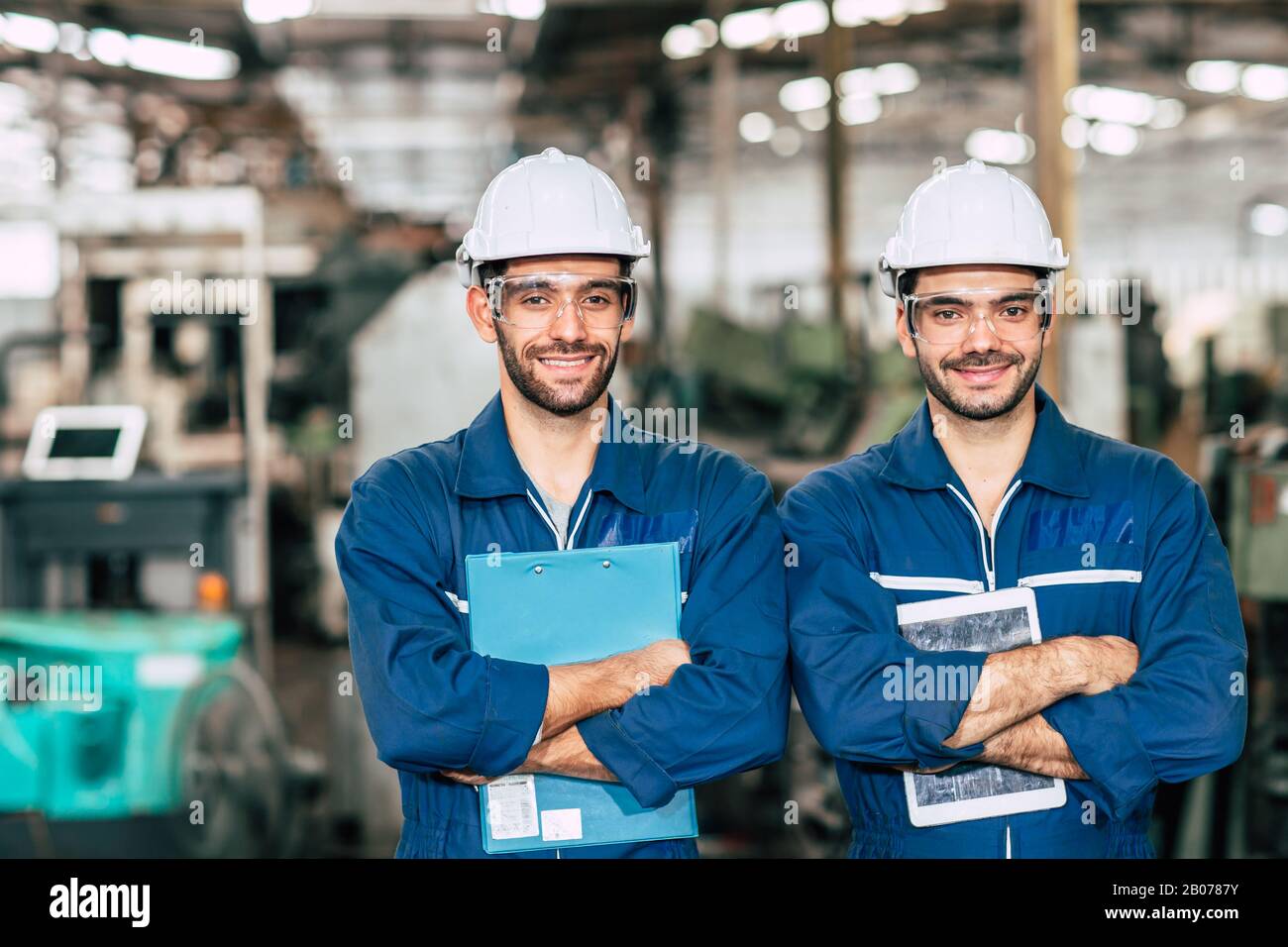 Portrait of Happy Engineer team smiling worker working together in industry factory. Stock Photo