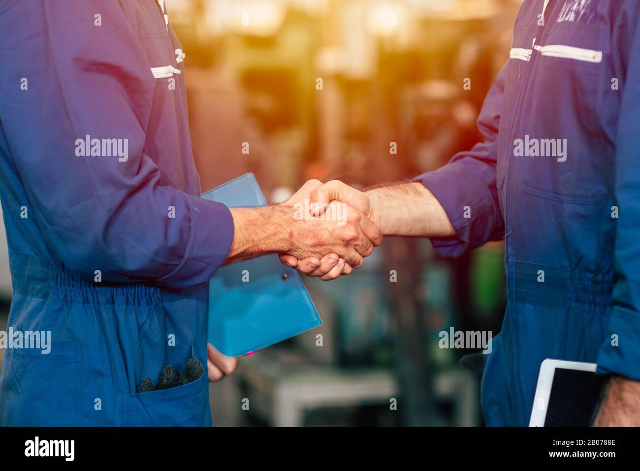 Worker team hand shaking to co-operated the factory engineer work or dealing job done. Stock Photo