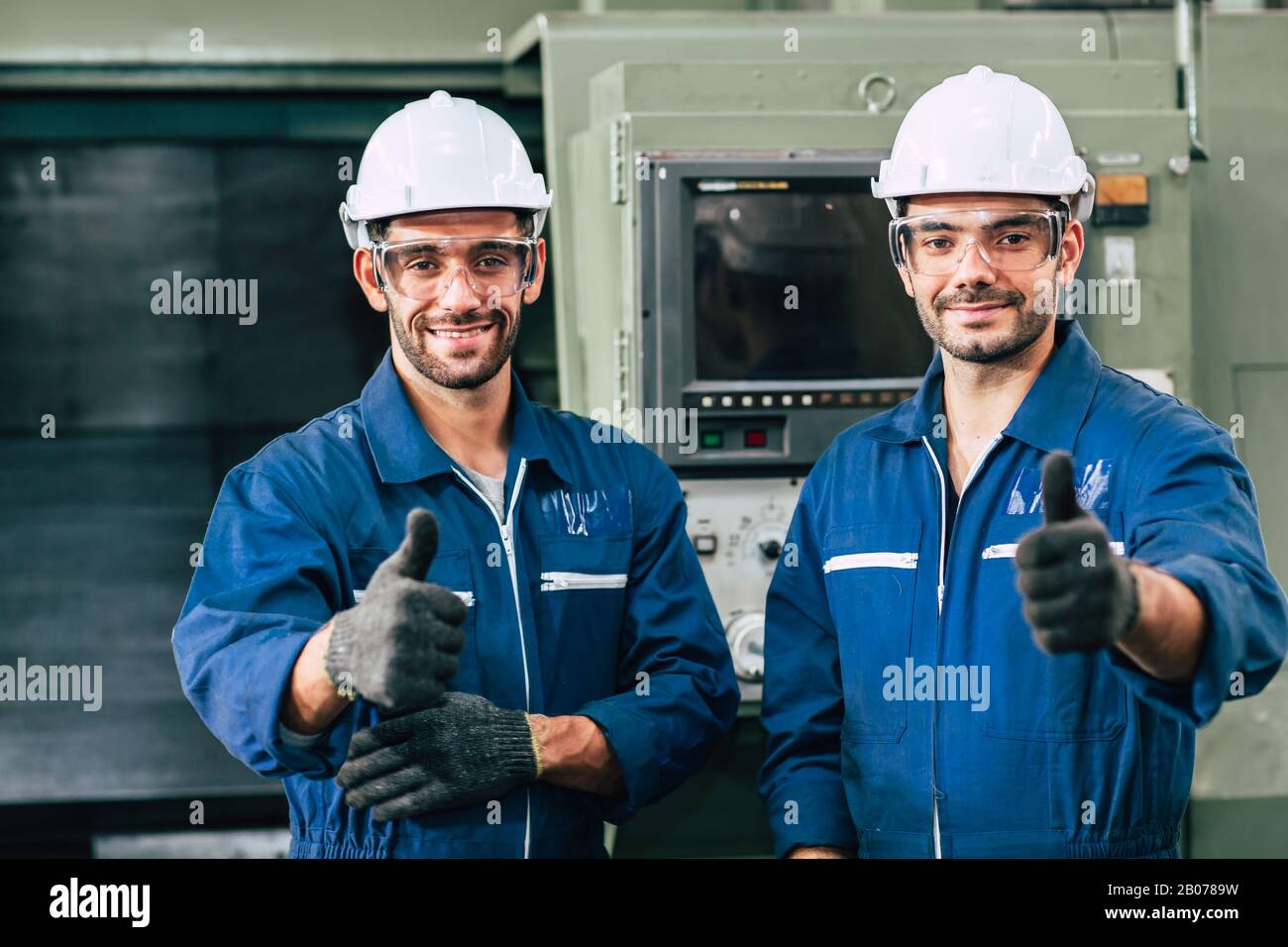 Happy worker team smiling hand show thumb up for good working in factory. Stock Photo