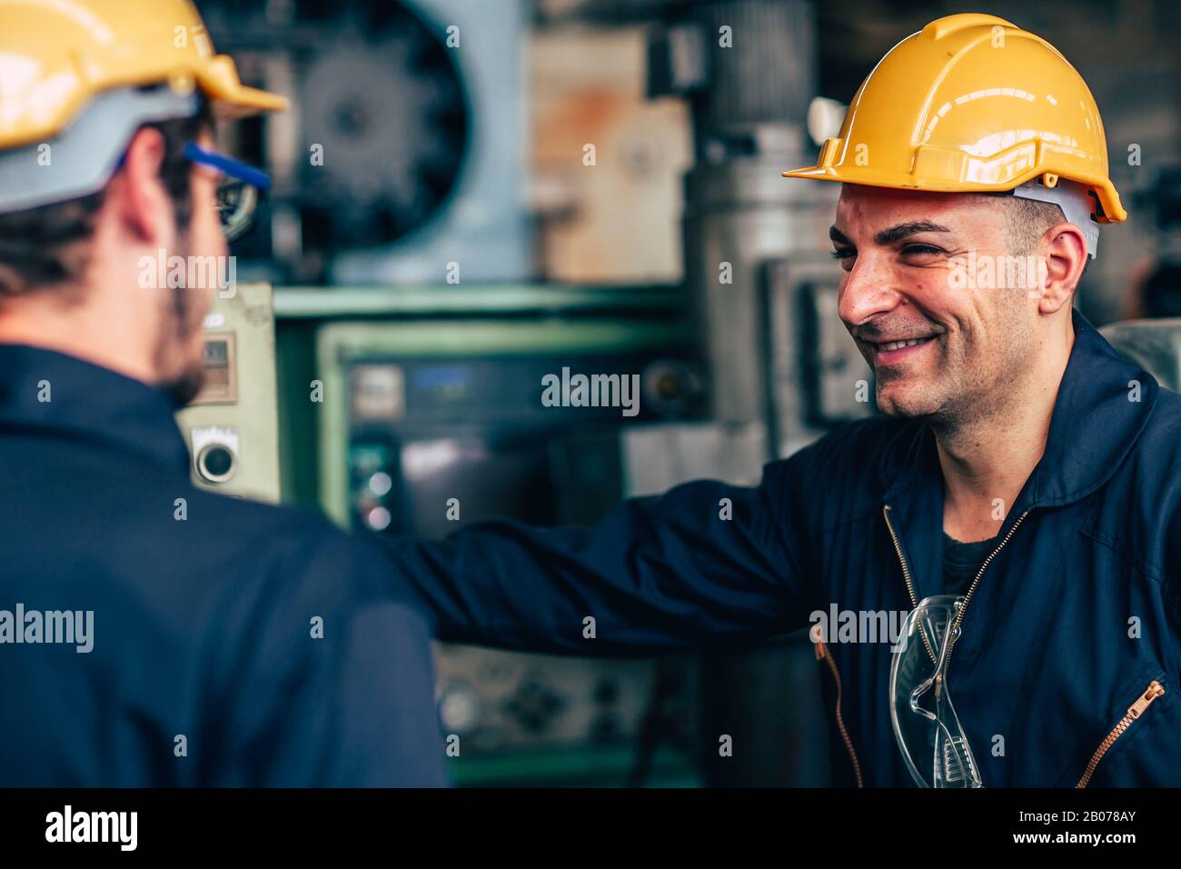 happy worker, smiling industrial technician engineer enjoy working together with coworker. Stock Photo