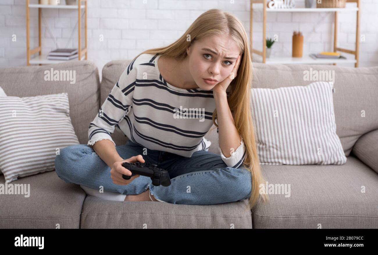 Bored girl playing video games alone at home Stock Photo Alamy