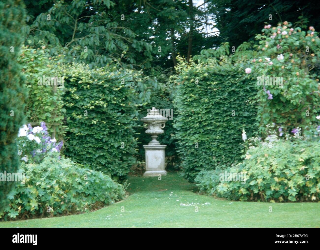 Sculpture placed in garden with large hedge Stock Photo
