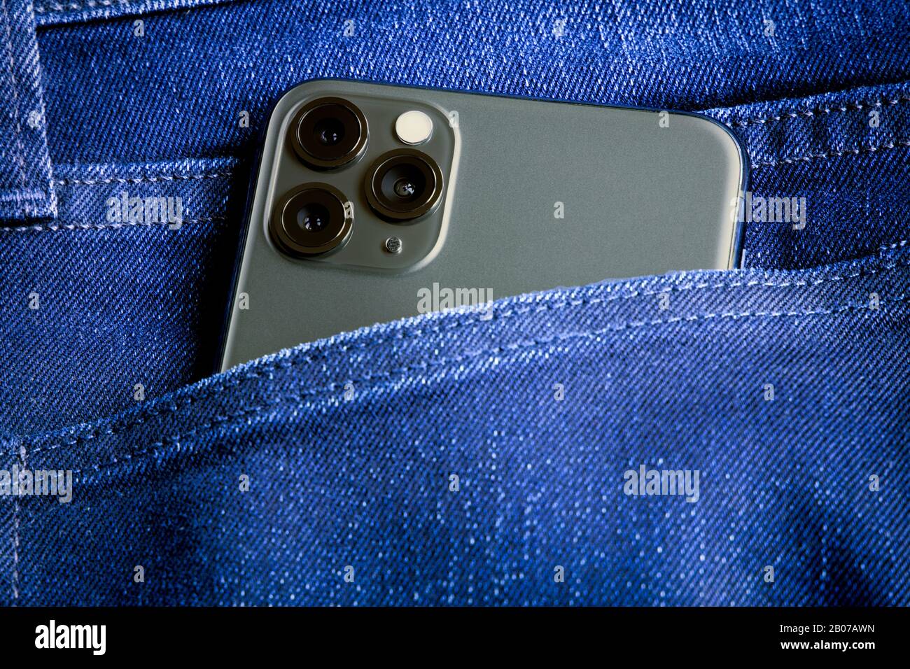 New Space Gray Apple iPhone 11 Pro MAX smartphone in jeans pocket close-up detail view the triple lens camera. Stock Photo