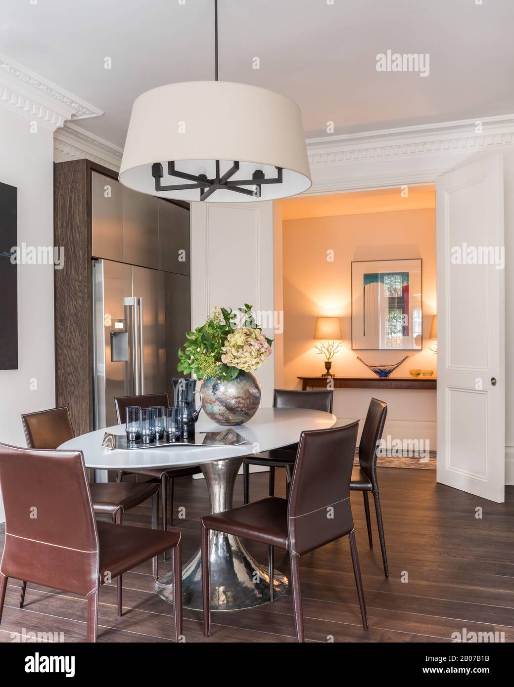 Dining table under pendant light by refrigerator Stock Photo - Alamy