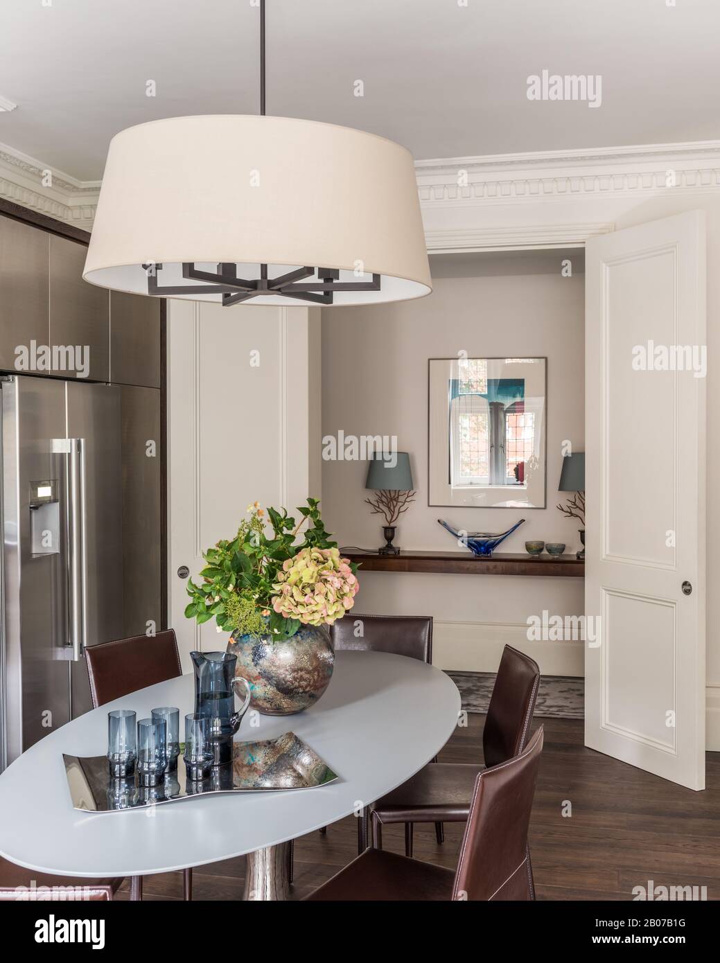 Dining table under pendant light by refrigerator Stock Photo