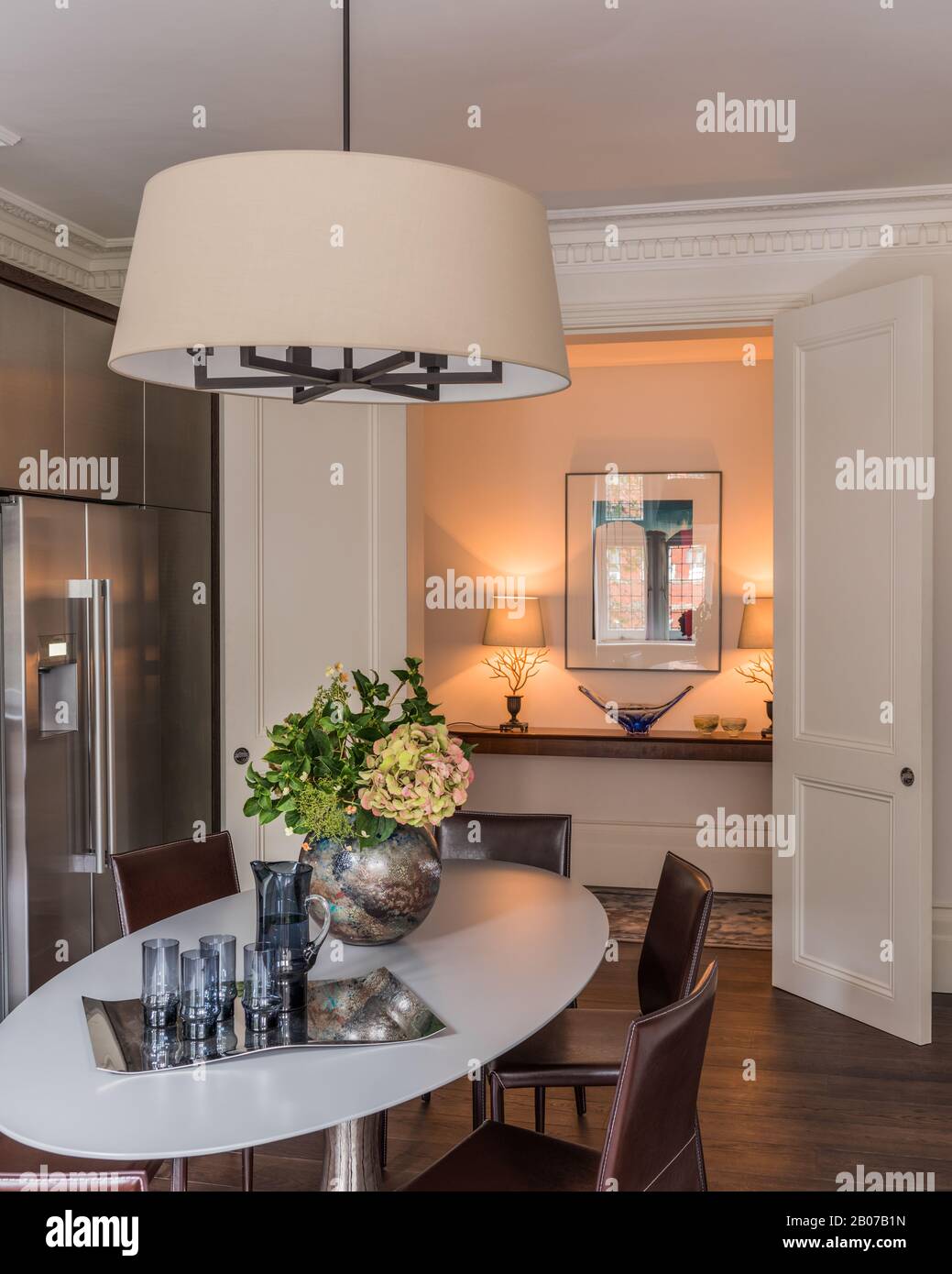 Dining table under pendant light by refrigerator Stock Photo - Alamy