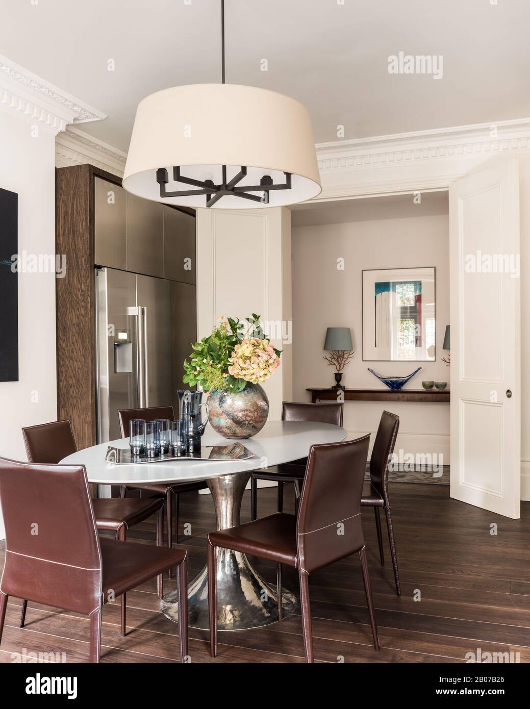 Dining table under pendant light by refrigerator Stock Photo