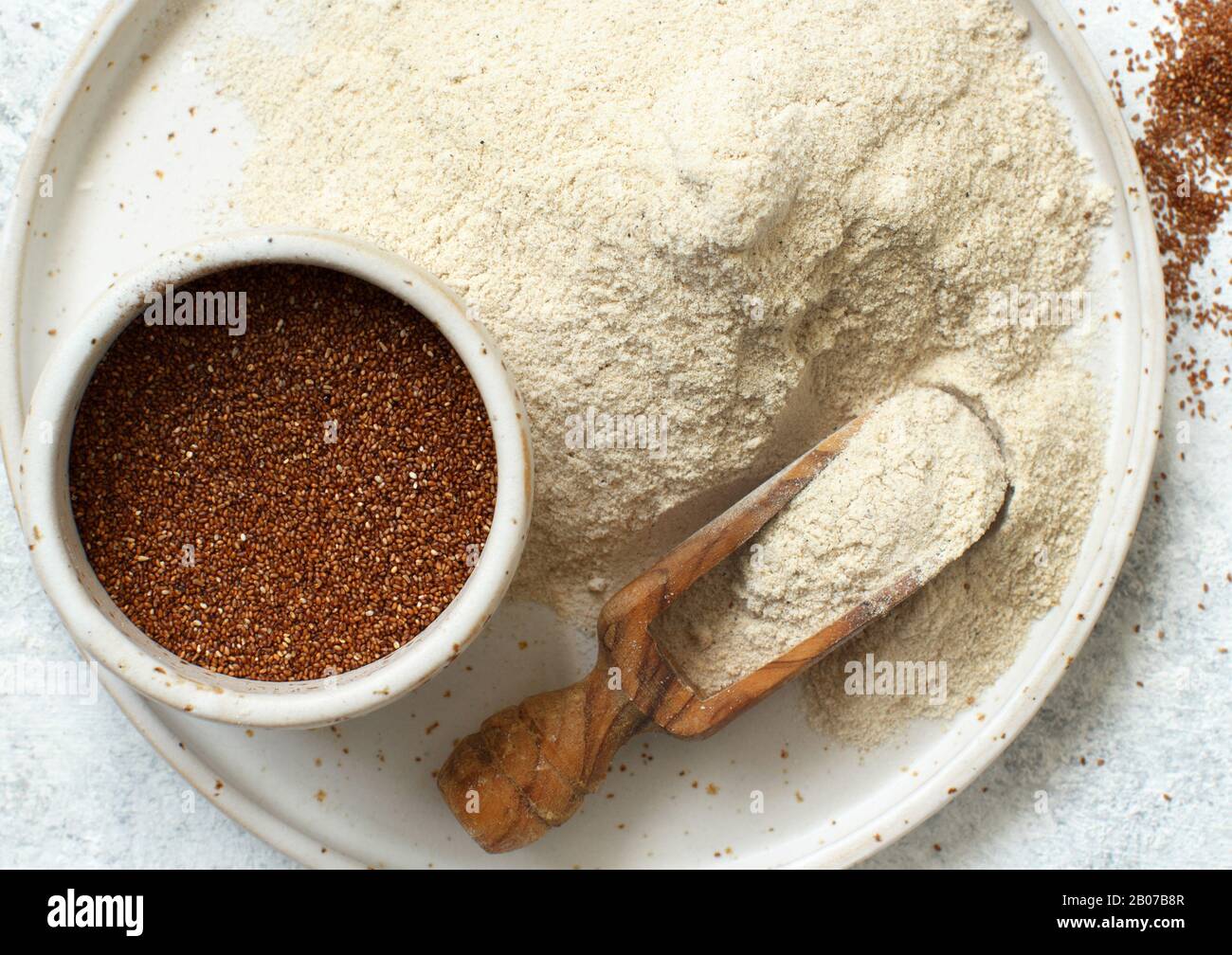 Teff flour on a plate and teff grain with a spoon top view Stock Photo ...