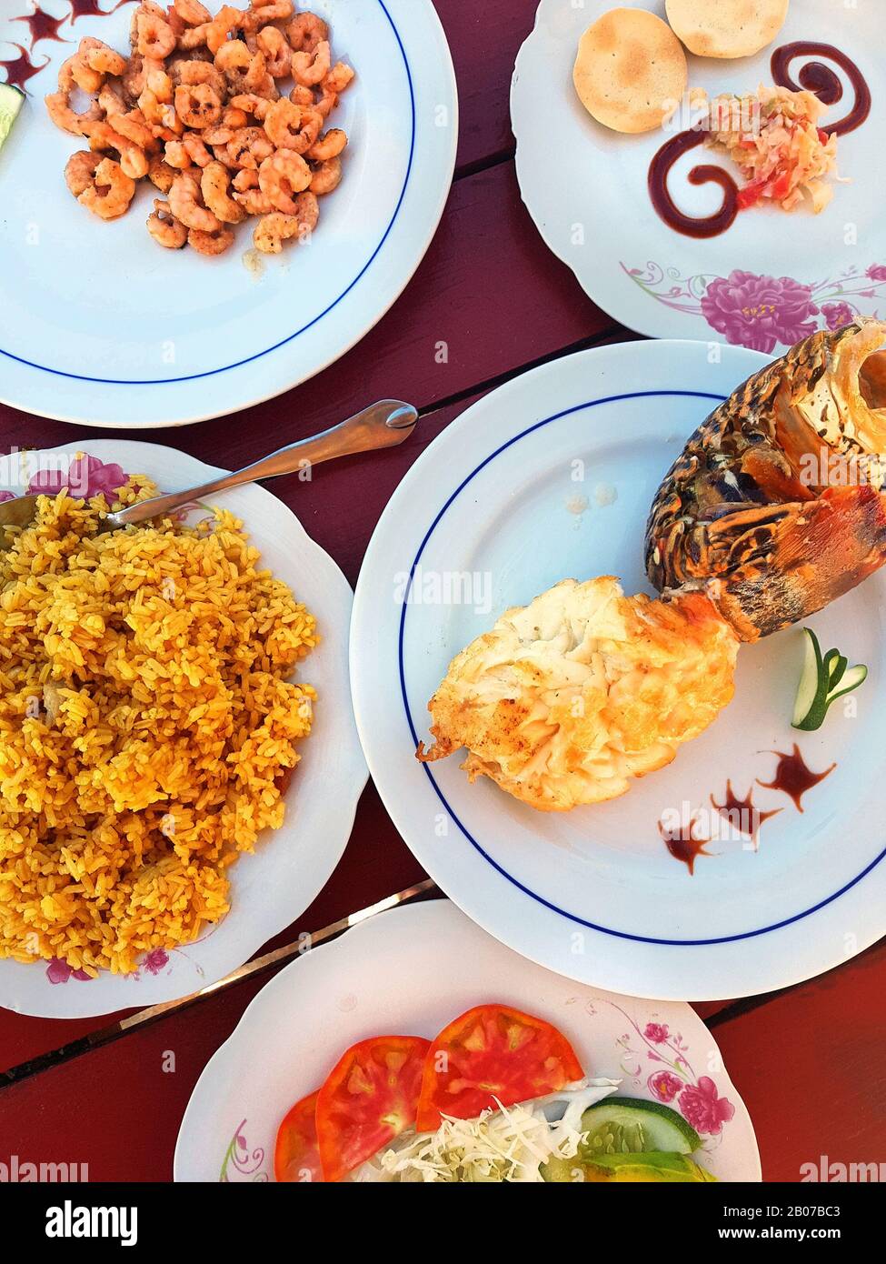 Grilled lobster on a plate,  shrimps, vegetables and rice in a Cuban beach restaurant Stock Photo