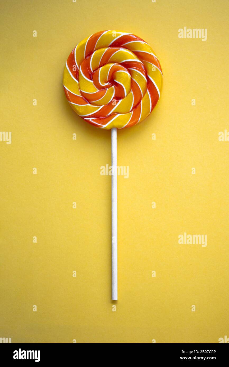 Download Bright Swirl Lollipop On Yellow Background Festive Vertical Background With Colorful Twisted Candy Close Up Of Rainbow Round Sweet On Stick Orange Stock Photo Alamy Yellowimages Mockups