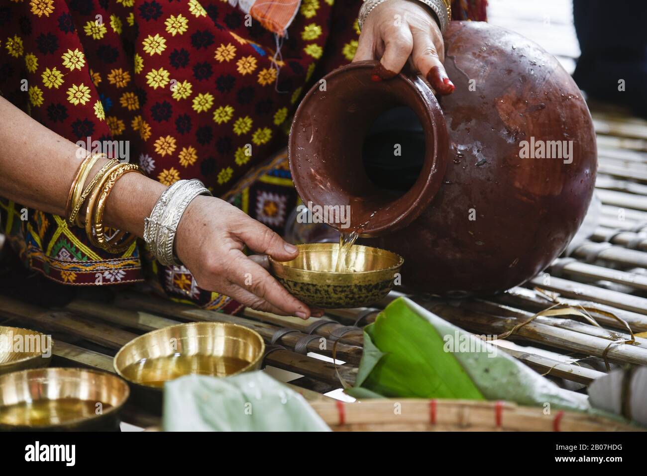 February 19, 2020, Guwahati, Assam, India: Mishing tribal woman pour Apong (homemade Rice wine)  during Ali-Aye-Ligang festival in Guwahati. Ali Ai Ligang is the most vibrant festival celebrated by the Mishing Tribe of people of Assam. The festival begins on the first Wednesday of the month of Fagun of the Assamese calendar. During this festival, Misings indulge in great banquet with Apong (homemade Rice wine) with various dishes. (Credit Image: © David Talukdar/ZUMA Wire) Stock Photo