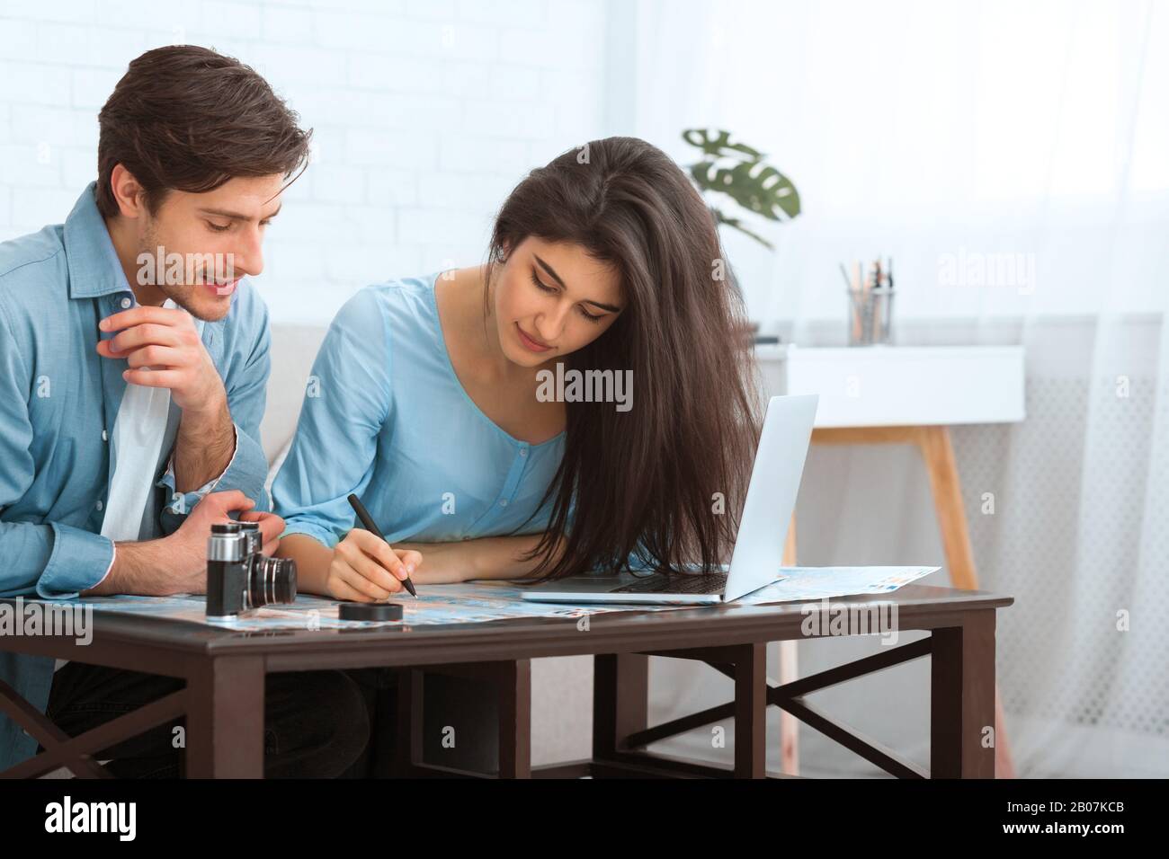 Planning trip. Young couple studying map and making notes Stock Photo