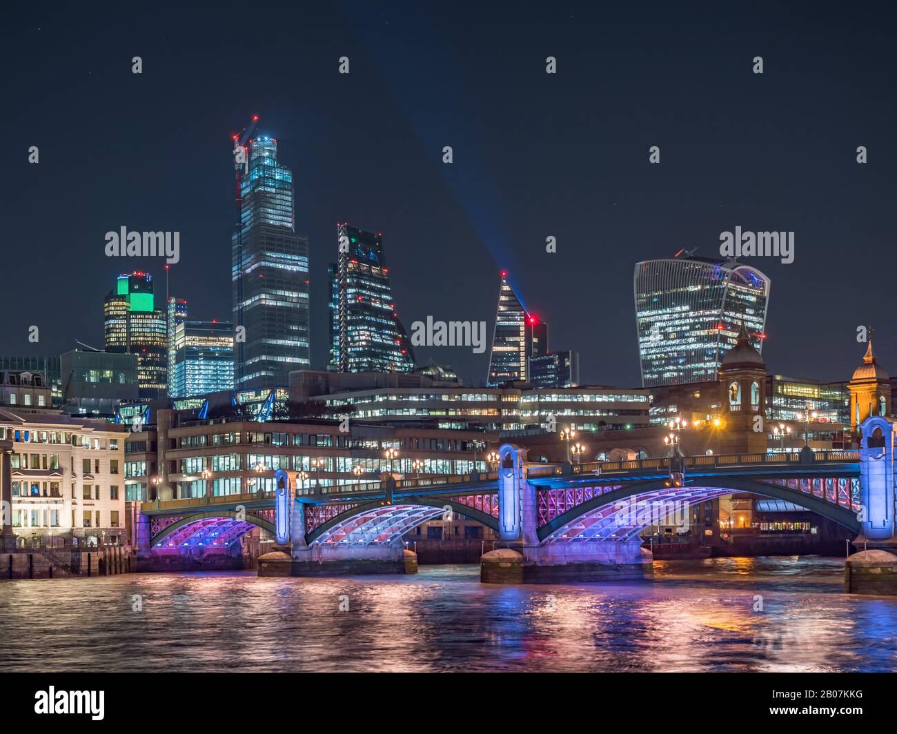 Night scenic view of the Thames river with Southwark bridge and financial district in the background.  Cityscape of London, United Kingdom Stock Photo