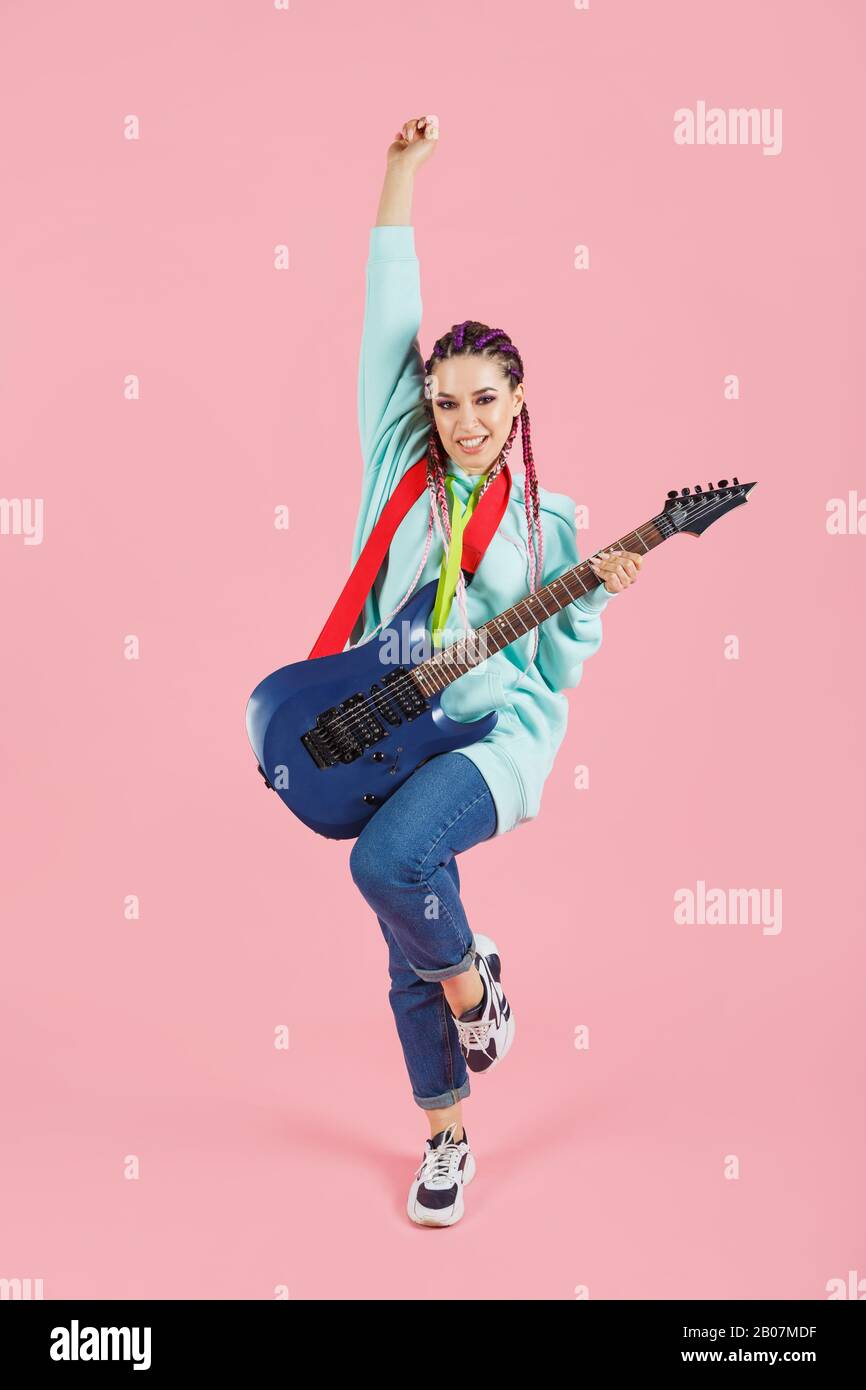 Young woman rock musician with amp isolated on pink Stock Photo
