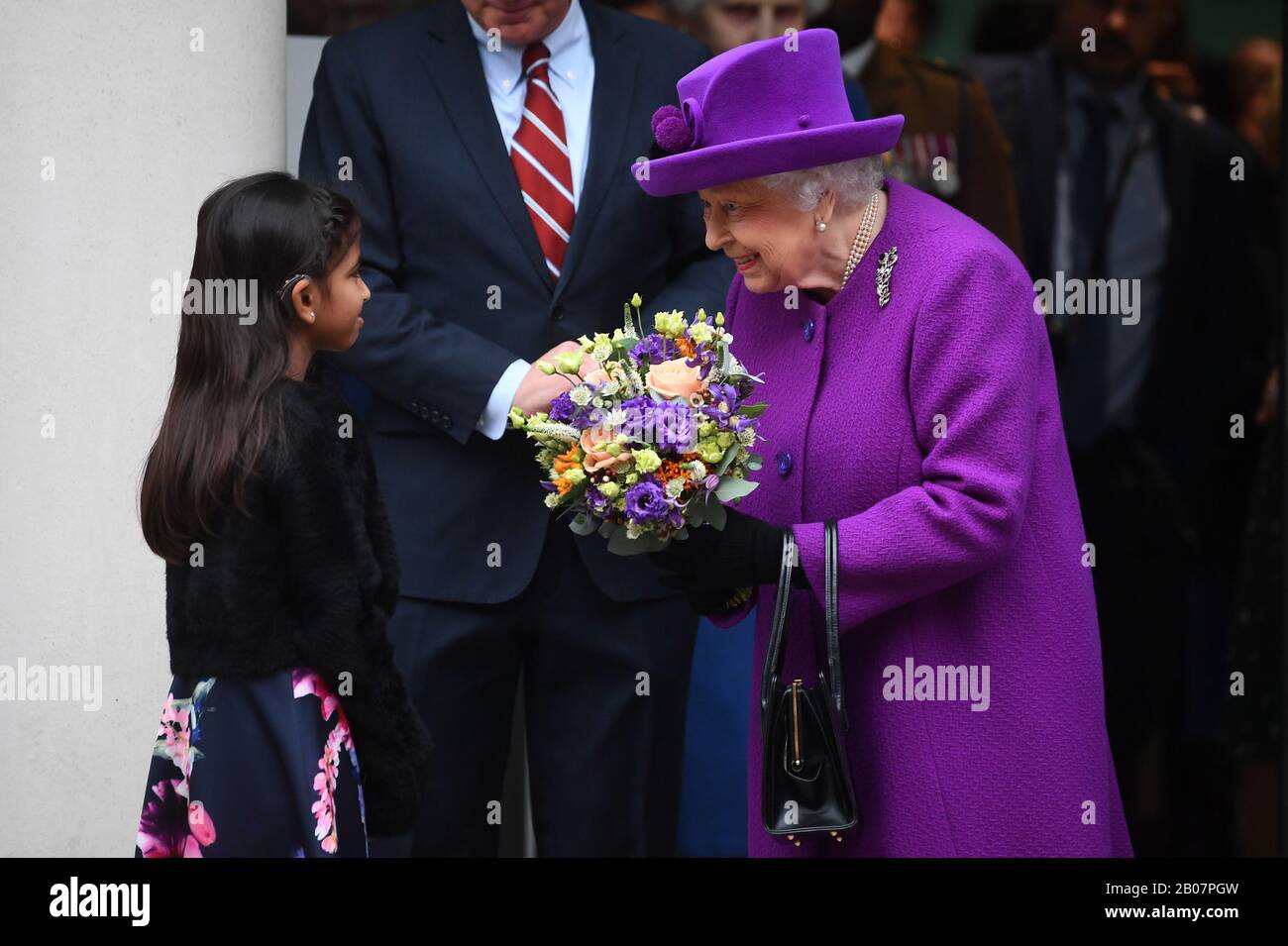 Queen Elizabeth II receives a bouquet from a young girl as she leaves after officially opening the new premises of the Royal National ENT and Eastman Dental Hospitals in London. PA Photo. Picture date: Wednesday February 19, 2020. See PA story ROYAL Queen. Photo credit should read: Victoria Jones/PA Wire Stock Photo