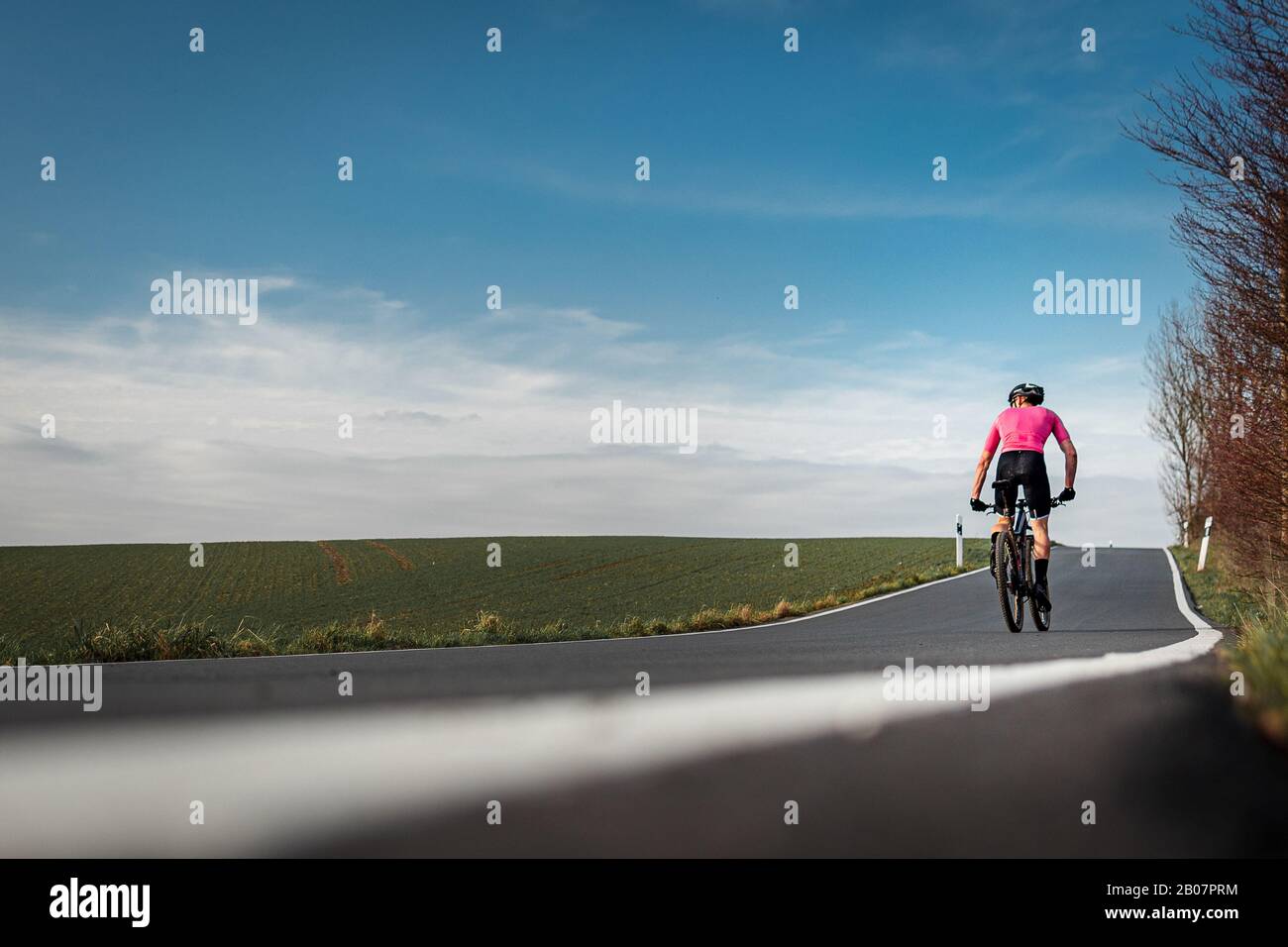 bicyclist on a background of the blue sky road bike back Stock Photo