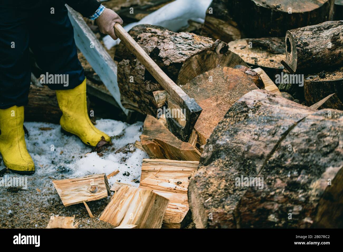 Man is chopping wood with vintage axe. Detail of flying pieces of ...