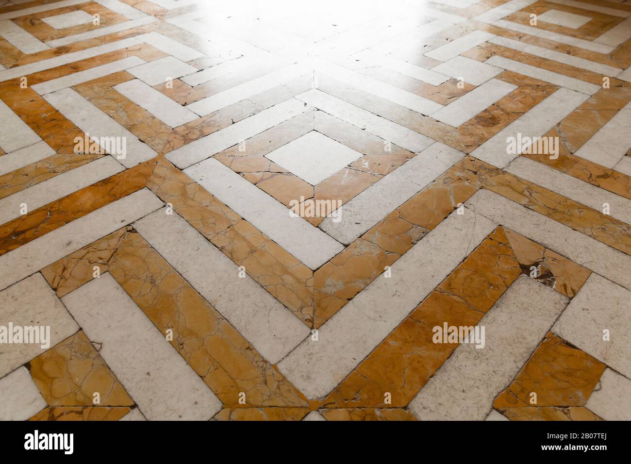 Old style shiny stone mosaic floor tiling with yellow white geometric ...
