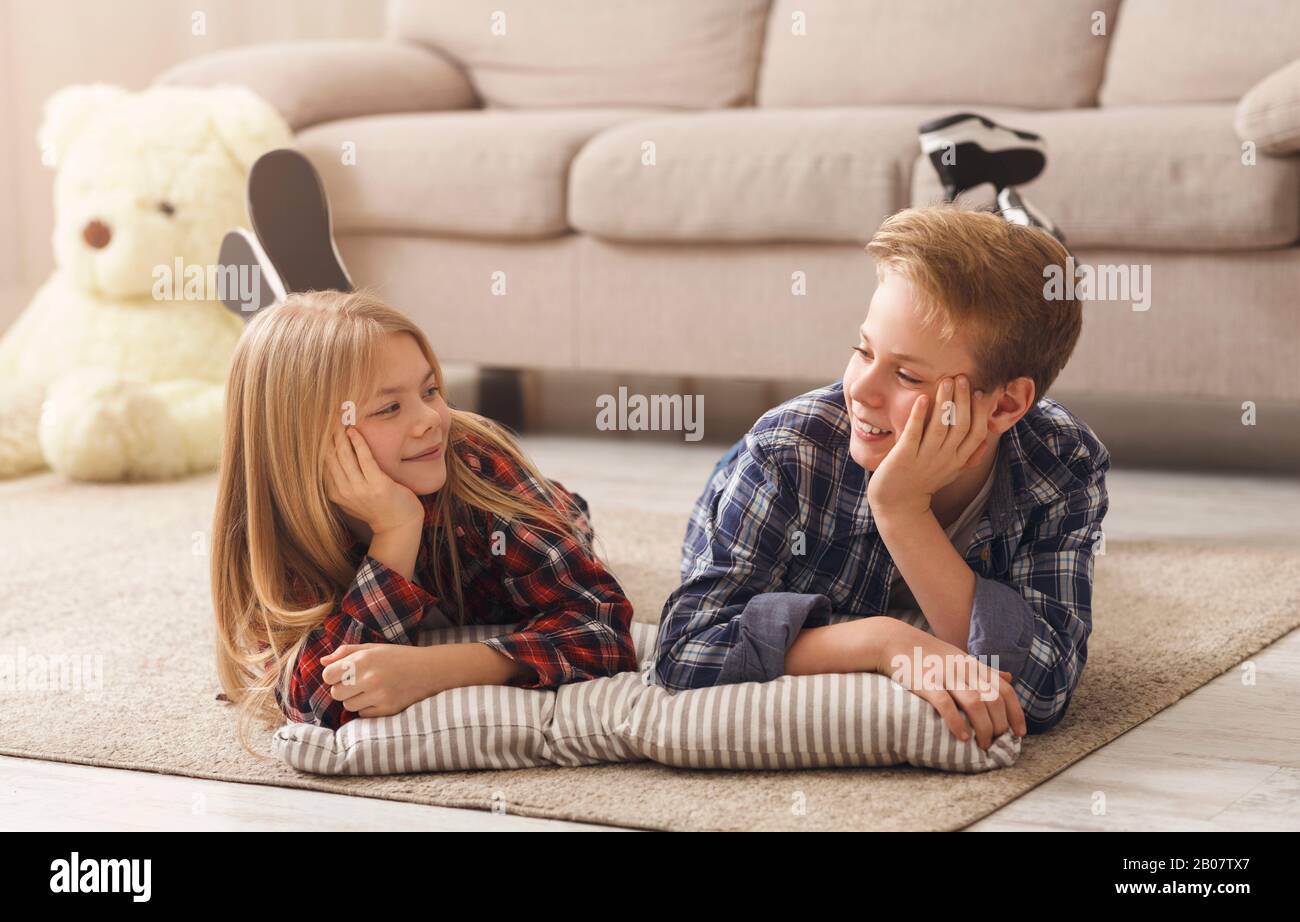 Boy And Girl Lying On Floor Smiling Each Other Indoor Stock Photo