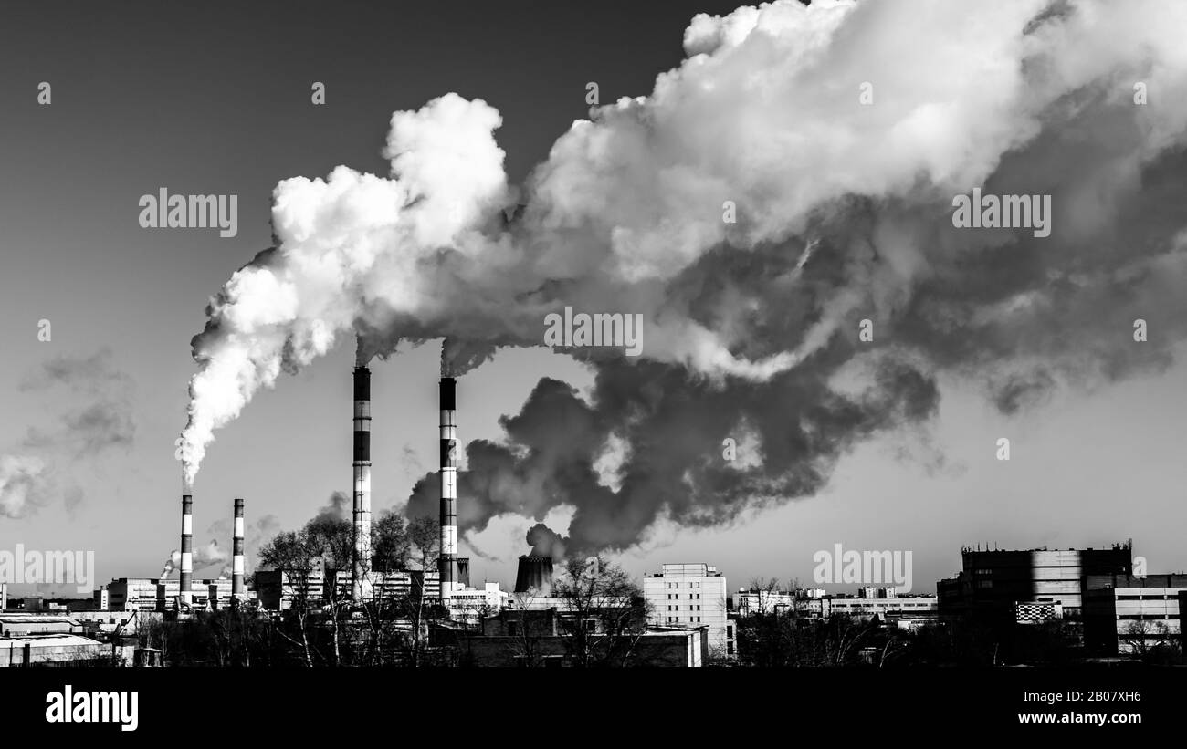 Black and white industrial landscape, swirling jets of smoke from factory chimneys poison the air with toxic waste. Vintage cityscape with smoke, air Stock Photo