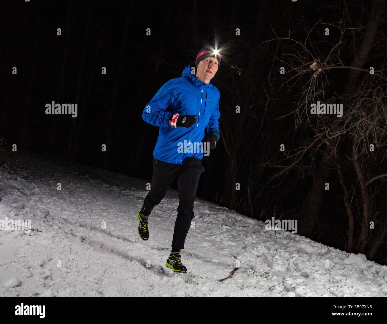 ALMATY KAZAKHSTAN: FEBRUARY 15, 2020: Unidentified people run at winer night in the mountains near the city of Almaty with flashlights during the Stock Photo