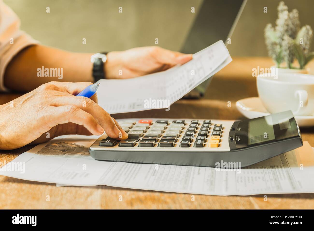 Businessman analyzing investment charts using calculator for profit and loss. Stock Photo