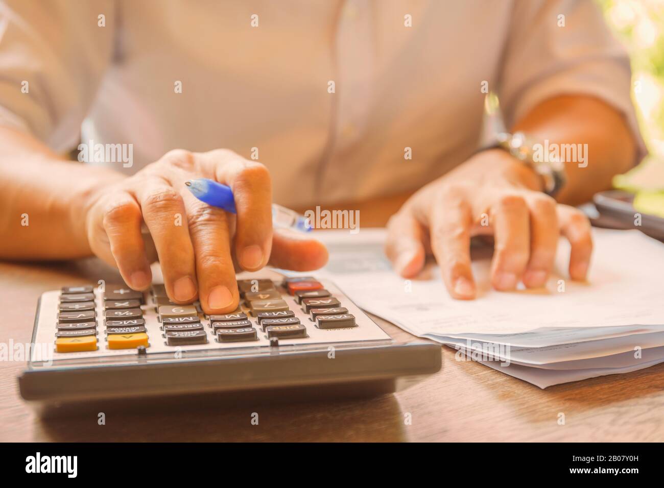 Businessman analyzing investment charts using calculator for profit and