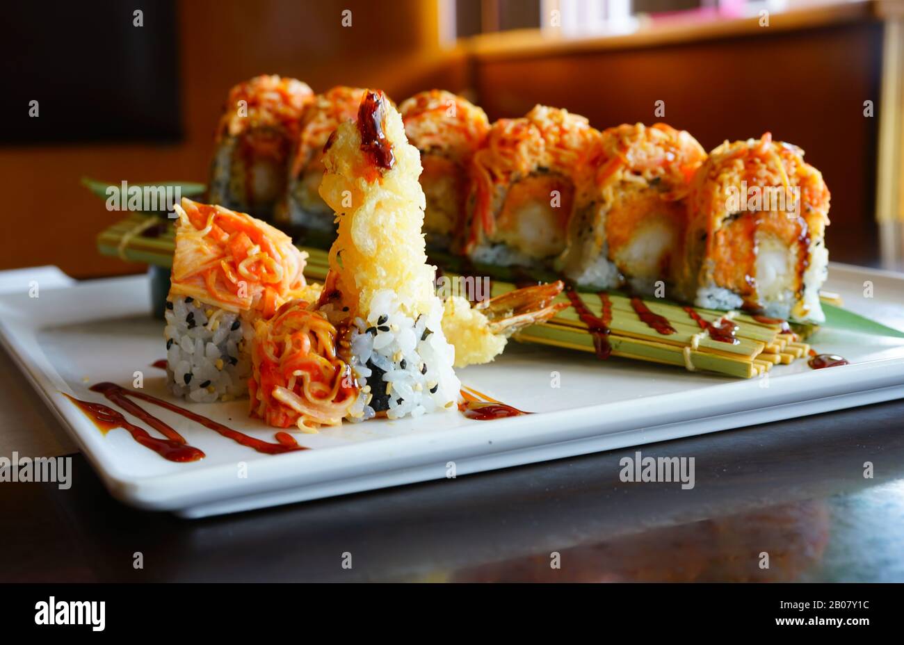 A plate of fried shrimp tempura and spicy crab sushi roll with eel
