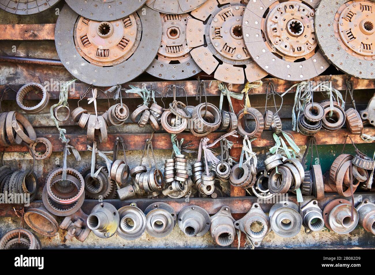Close-up of an array of used rusty old bearings and discs hanging in line in a auto junk shop in Iloilo City, Philippines, Asia Stock Photo
